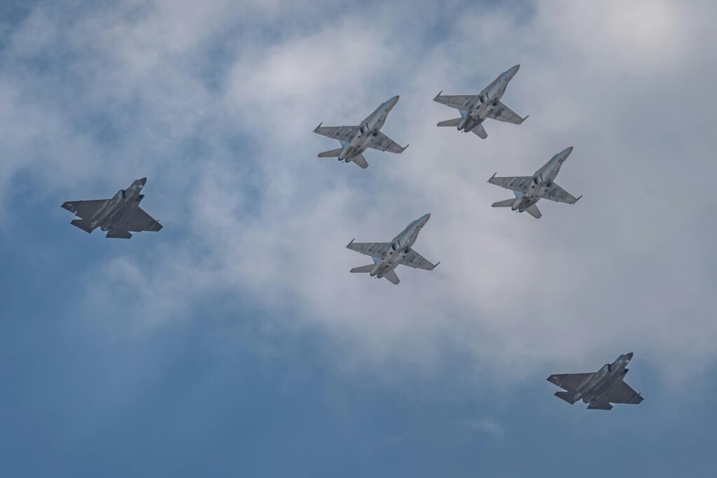 Jets performing in a spectacular aerial formation against a blue sky at an airshow.